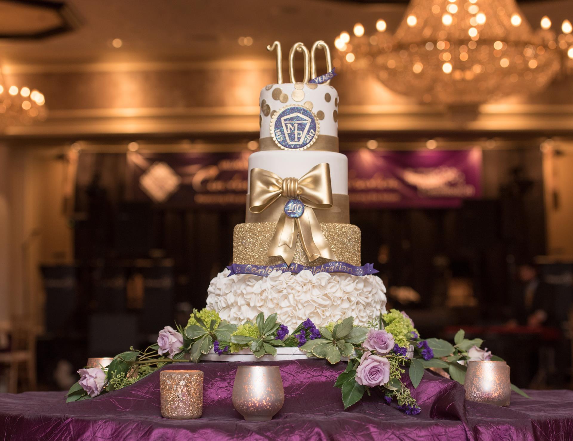 A stunning three-tier cake decorated in purple and gold